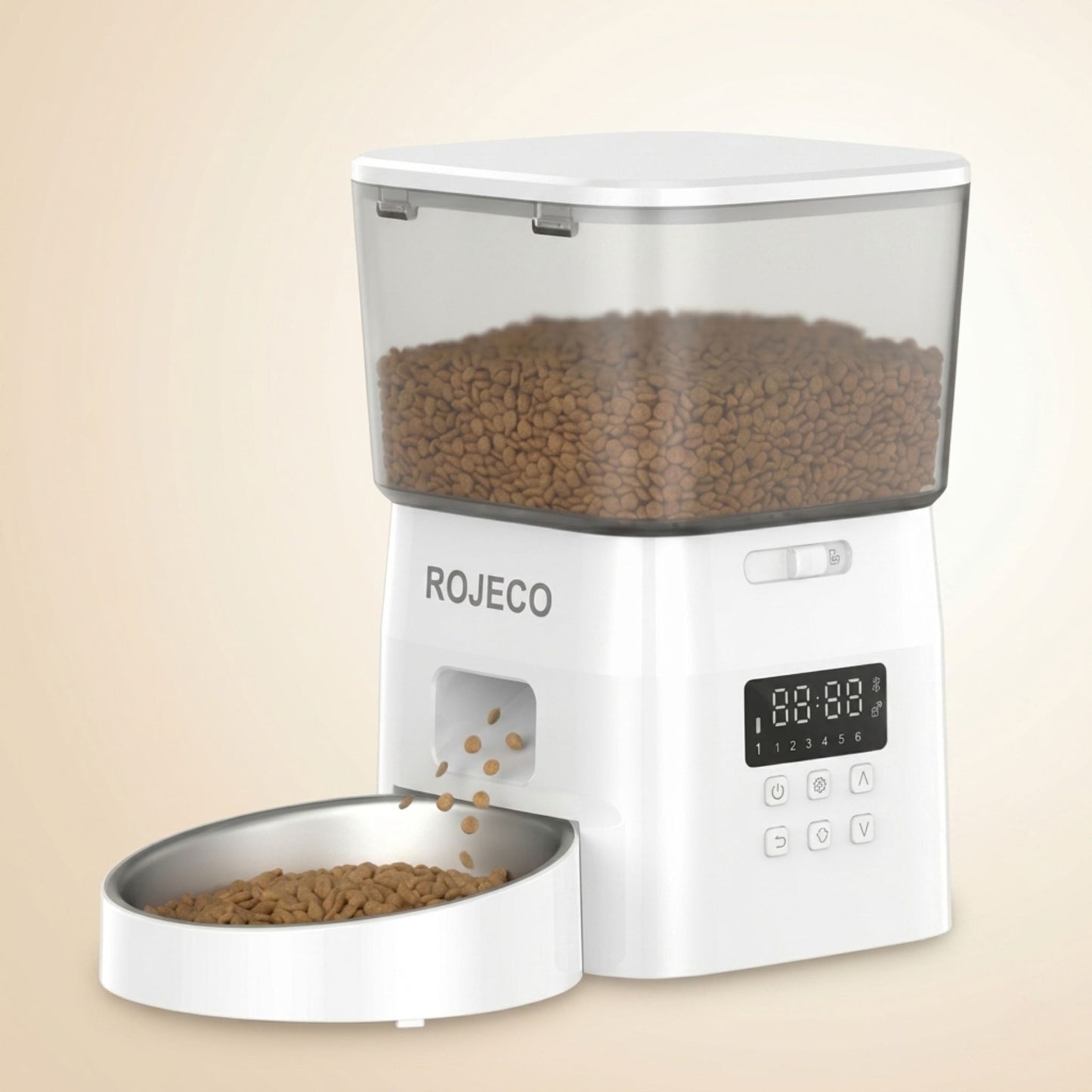 distributeur automatique croquettes pour chat blanc avec réservoir transparent plein de croquettes, bol inox et croquettes qui tombent, fond beige crème