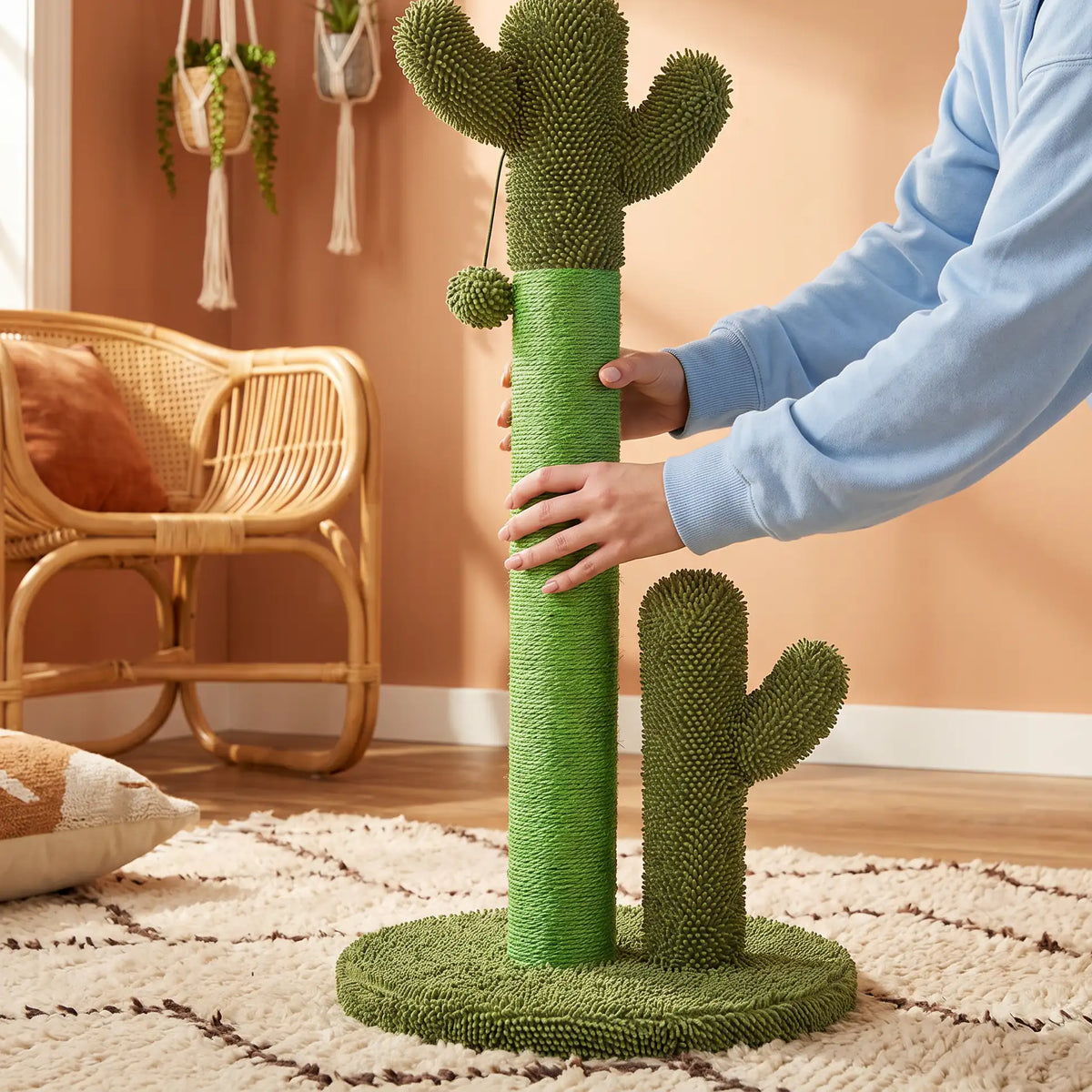 Mains qui fixent un poteau cactus sur le socle rond du griffoir