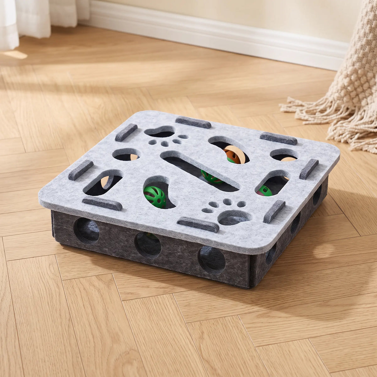 Jouet puzzle pour chat au plateau carré gris clair sur caisson anthracite, barres de feutre en relief