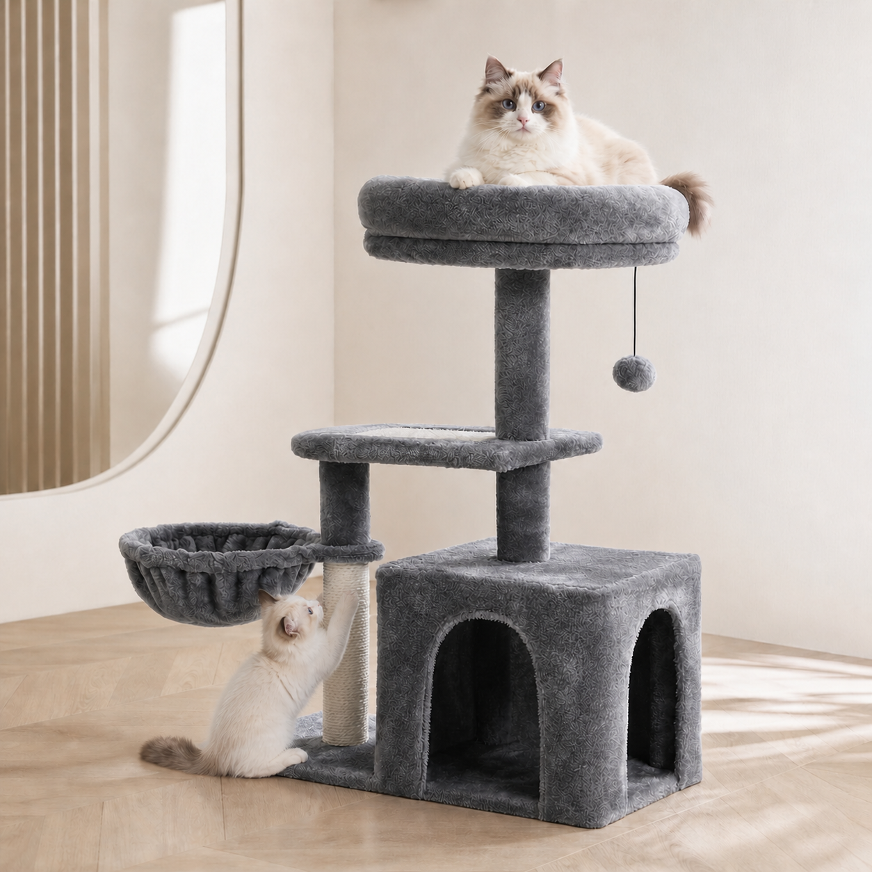 Deux chats ragdoll sur un arbre à chat gris anthracite compact avec cabane, corbeille suspendue, grand perchoir rembourré et griffoir en sisal, salon beige aux tons naturels.