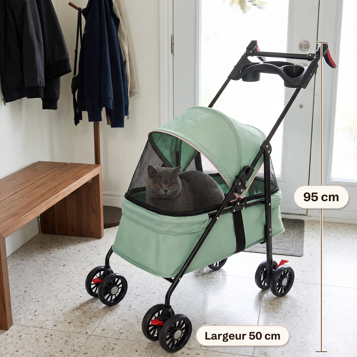 Poussette pour chat vert menthe de 95 cm de haut et 50 cm de large dans une entrée, un chat gris assis dans la nacelle